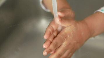 child washing hands with warm water at kitchen sink video