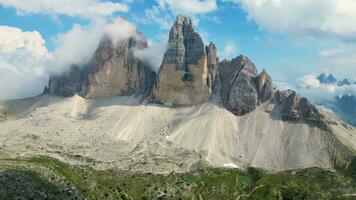 antenn se av Tre cime di lavaredo berg under en solig dag med moln och dimma i de dolomiterna, Italien. dramatisk och filmiska landskap. mycket känd platser för vandring och sten klättrande. video