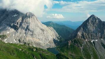 antenn se av volaia sjö, wolayersee, i de gräns av Italien och österrike med coglians berg i de bakgrund. molnig dag med några Sol öppning. vibrerande färger. skön destinationer för vandrare video