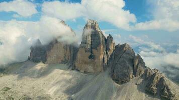 aérien vue de tre cime di lavaredo Montagne pendant une ensoleillé journée avec des nuages et brouillard dans le dolomites, Italie. spectaculaire et cinématique paysage. très célèbre des endroits pour randonnée et Roche escalade. video