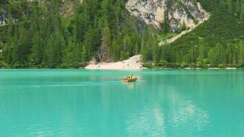 se över sjö braies eller pragser wildsee i de dolomiterna, ett av de mest skön sjöar i Italien. båtar i de mitten av de sjö omgiven förbi berg. resa och fritid. video