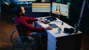 Photo editor in wheelchair color correcting photographs in personal studio. Freelancer with locomotor disability selecting best pictures for editorial content using retouching software video