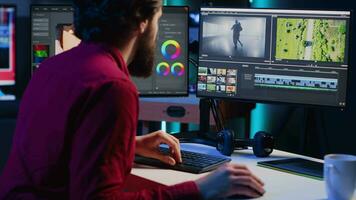 professionell video redaktör analyserar filma montage innan redigering Färg gradering och belysning i kreativ kontor. posta produktion studio anställd arbetssätt med rå antal fot, förbättra kvalitet