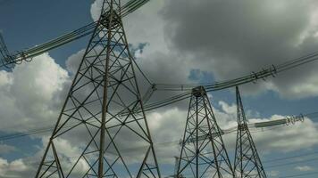 Timelapse of clouds moving over high voltage pylons. Electricity crisis in the world. Green energy in power lines. Power generation. 4K video