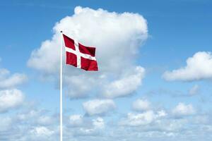 bandera de Dinamarca en contra azul cielo foto