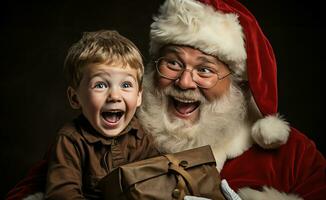 padre Navidad tiene un chico en su regazo y riendo manos terminado regalos foto