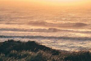 Huge waves at north sea coast in sunset photo