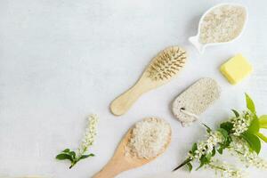 Concept of Spa-cosmetic and cosmetic procedures. Spa-sea salt in a white dish, wooden comb, penza, flower on a light concrete background. The concept of a waste-free lifestyle. copyspase. photo