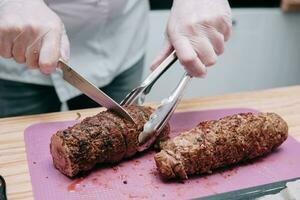 Cooking meat rolls in the cooking class. Beef roll with spices. The process of cutting a roll, close-up. photo