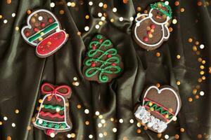 Banner for Christmas and New Year gingerbread. Christmas trees, toys, snowmen, garlands on a background of brown silk fabric. Bright bokeh. photo