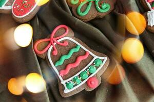 Banner for Christmas and New Year gingerbread. Christmas trees, toys, snowmen, garlands on a background of brown silk fabric. Bright bokeh. photo