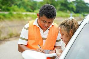 Closeup the insurance company officers write an accident report for customer claim. Traffic accident and insurance concept photo