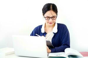 Closeup Asian young female student in casual cloth make a short note on tablet for the exam on white gradient background. Asian school concept. photo