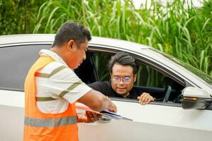 Closeup the insurance company officers for customers to sign a claim report form after an accident. Traffic accident and insurance concept photo