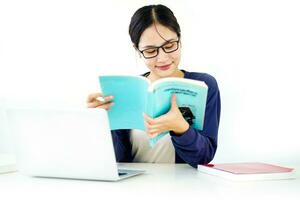 Closeup Asian young female student in casual cloth reading a textbook for the exam on white gradient background. Asian school concept. photo