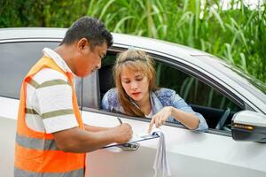 Closeup the insurance company officers write an accident report for customer claim. Traffic accident and insurance concept photo