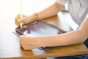 de cerca y cosecha manos de estudiante utilizando y estudiar en tableta a colegio con Dom llamarada antecedentes. red educación concepto. foto