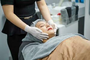 cosmetólogos preparación para un facial y spa tratamiento a mujer cliente en belleza clínicas, spa y belleza piel concepto. foto