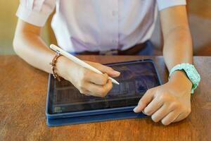 Closeup and crop hands of Student using and study on tablet at school with sun flare background. Network education concept. photo