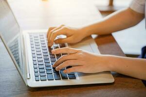 Closeup hands of woman type a laptop keyboard photo