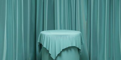 Empty round podium with background covered with turquoise cloth. Stand against photo