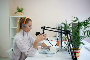 young woman is streaming while sitting in coworking at the computer photo