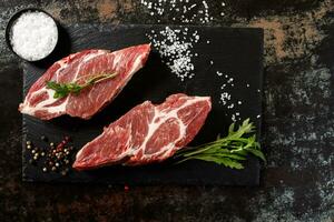 cerdo crudo con especias para cocinar al fuego o al horno sobre un fondo de piedra oscura foto