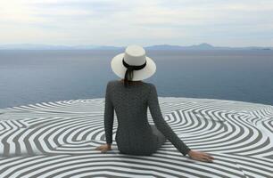 AI generated woman wearing hat sitting on top deck overlooking ocean photo