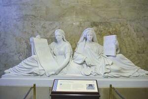 Washington DC, USA, 2023. Marble statues of Justice and History featuring two draped women reclining against a globe inside the Capitol building in Washington DC photo