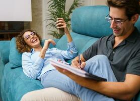 Happy couple spending time together over couch in living room photo