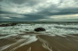 belleza nublada, paisaje marino de larga exposición con obturador lento y olas que fluyen. foto