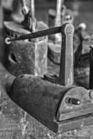 Ancient vintage irons for the clothes ironing. Black and white photo