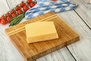 Piece of natural organic cheese over board photo