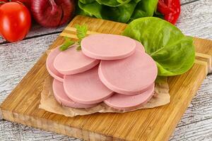 Slices boiled sausages for breakfast photo