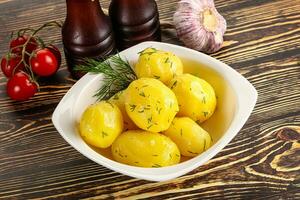 Boiled potato with oil and dill photo