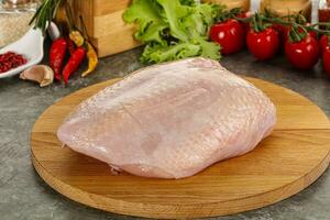 Raw chicken breast with skin photo