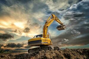 Crawler excavator during earthmoving works on construction site at sunset photo