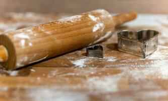 a rolling pin with flour and cookie molds photo