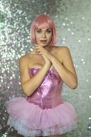 Woman in a pink wig with short hair on a silver shiny background photo