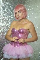 Woman in a pink wig with short hair on a silver shiny background photo