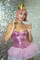 Woman in pink wig with gold crown. Halloween photo