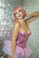 Woman in a pink wig with short hair on a silver shiny background photo