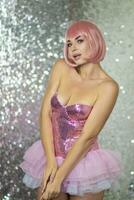 Woman in a pink wig with short hair on a silver shiny background photo