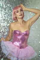 Woman in a pink wig with short hair on a silver shiny background photo