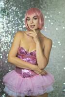 Woman in a pink wig with short hair on a silver shiny background photo