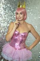 Woman in pink wig with gold crown. Halloween photo