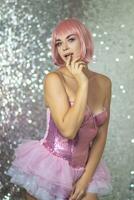 Woman in a pink wig with short hair on a silver shiny background photo