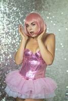 Woman in a pink wig with short hair on a silver shiny background photo