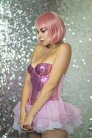 Woman in a pink wig with short hair on a silver shiny background photo