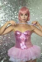 mujer en un corto rosado peluca con un magia varita mágica foto